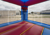 Red and blue inflatable bounce house with a school building in the background