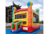 A colorful inflatable children's bounce house with a slide, photographed outdoors on a blue ground cover with trees and sky in the background.