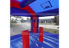 Blue and red inflatable bounce house with red cylindrical pillars and a transparent floor showing an outdoor paved area and building in the background.