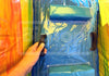 Blue raincoat with a zipper held by a hand against a colorful background