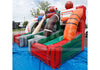 Outdoor inflatable bounce house with football-themed slides and walls, including a red and green slide, an orange spiral slide, a brown tunnel, and football graphics, set up on a blue tarp outdoors.