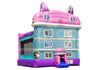A pink and light blue inflatable bouncy castle with cat-themed roof details, windows, and a small slide, shown on a plain white background.