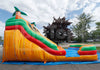Colorful inflatable slide and obstacle course on a paved surface with trees and cars in the background.