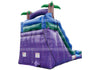 Purple and blue inflatable bouncy castle with green palm tree accents, isolated on a white background.