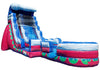 An inflatable water slide playground with a pink and blue body, featuring a clear water slide, a splash pool, and green scalloped accents on a white background.